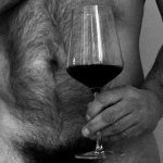 a naked man and a glass of wine photo